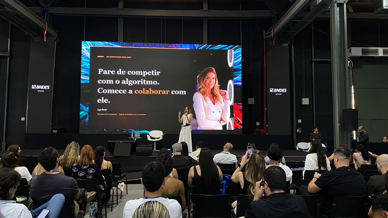 No palco do Conecta Varejo, Lys Prol apresenta as vantagens de parar de competir com o algoritmo e colaborar com ele