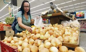 Mulher colhe batatas no hortifruti do supermercado